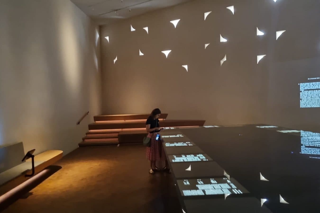 A visitor with a guide device in a museum gallery